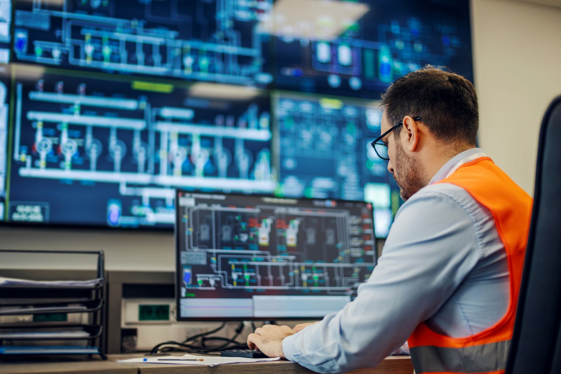 Operator monitoring process screens in an industrial control room